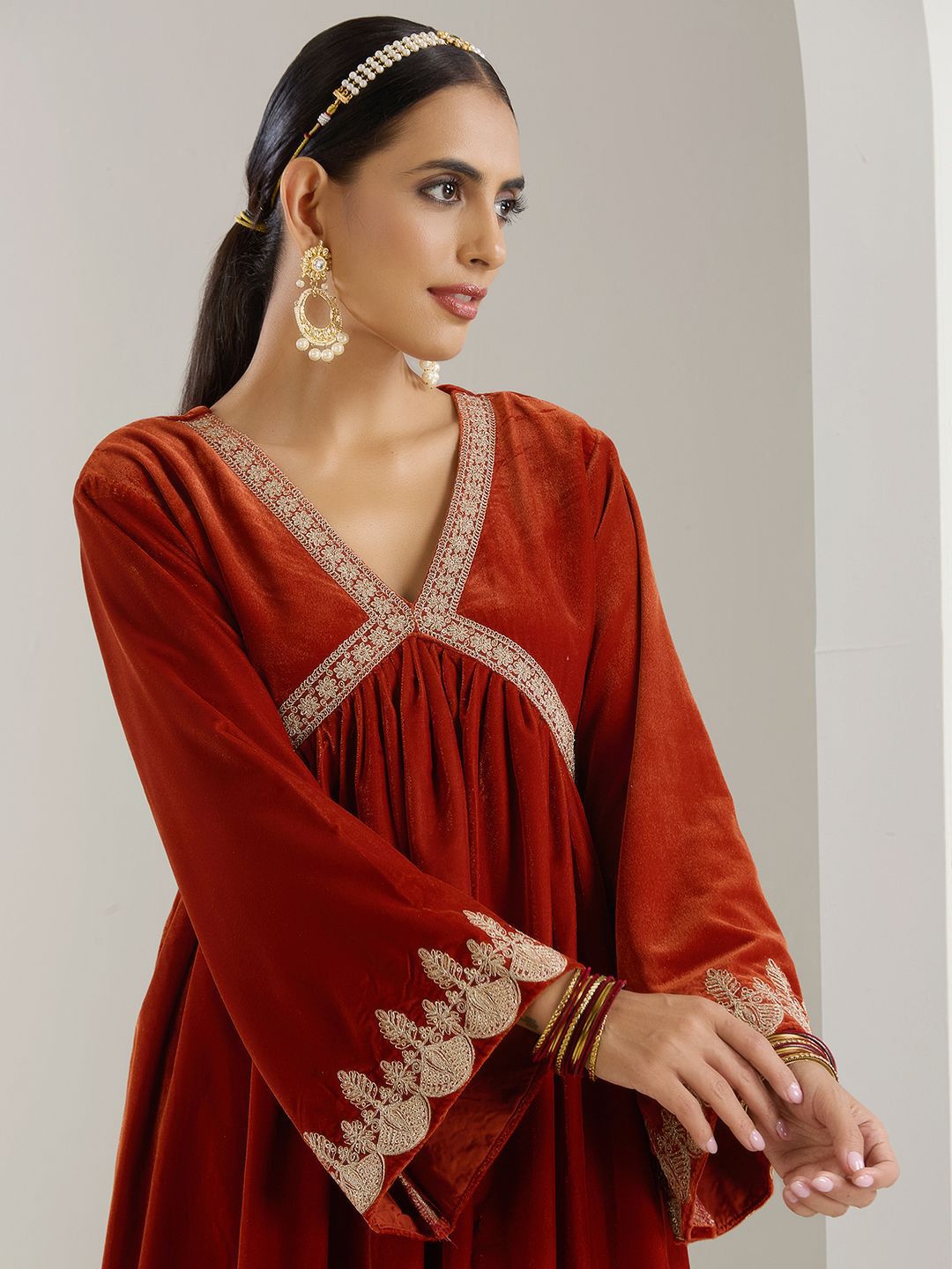 Rich Velvet Gold Zari Embroidered Rust A-Line Kurta Set With Straight Bottom & Scalloped Sleeves.
