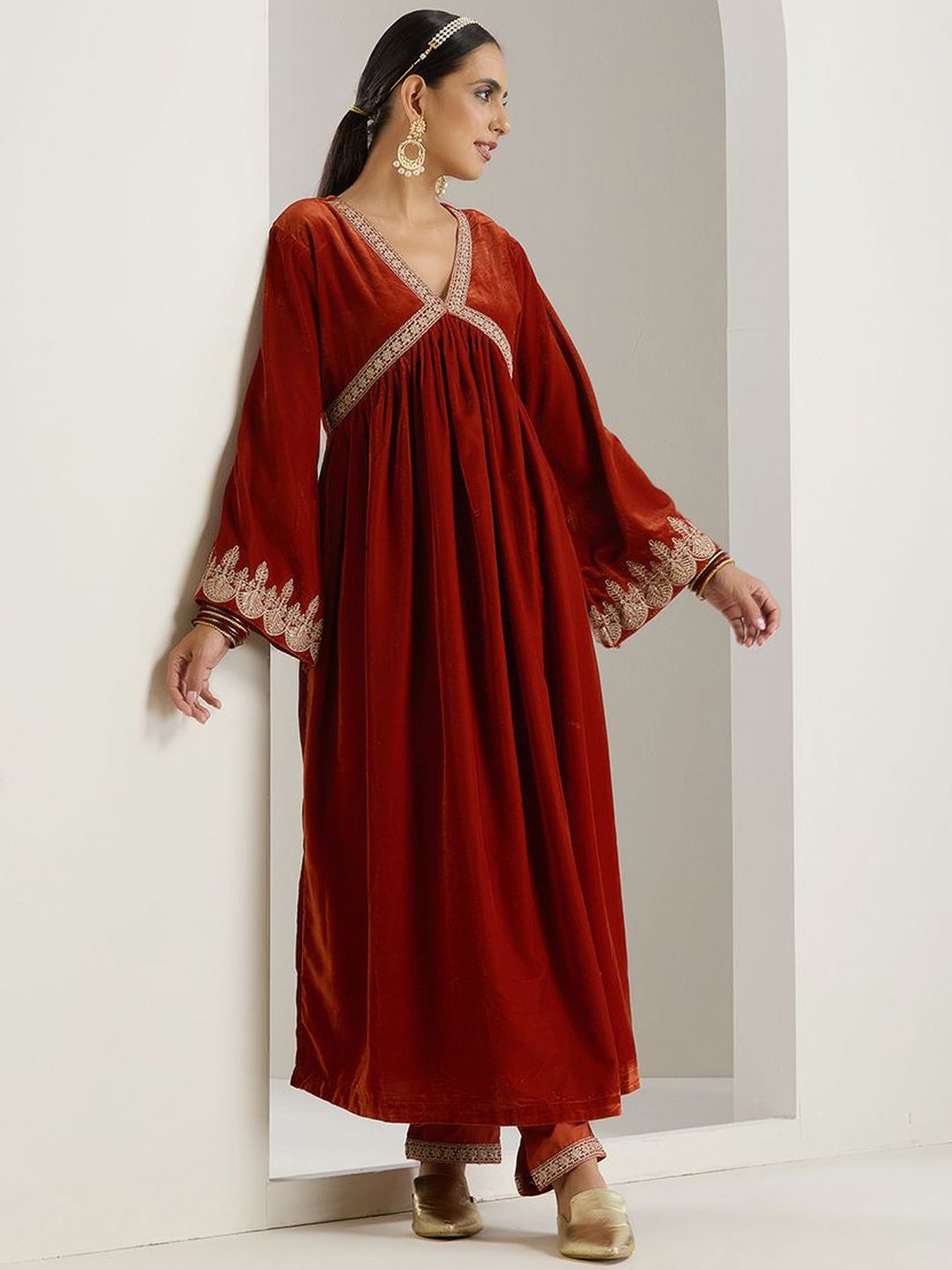 Rich Velvet Gold Zari Embroidered Rust A-Line Kurta Set With Straight Bottom & Scalloped Sleeves.